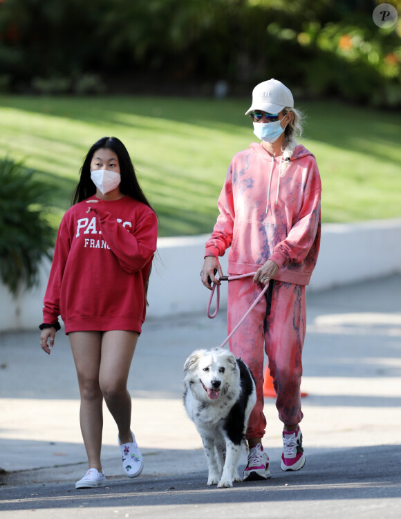 Christina arrive en fin d'après-midi chez Laeticia avec son chien Bono et des masques de protection à la main. Laeticia Hallyday, ses filles Jade et Joy, Christina, avec des masques, et leurs chiens Santos, Cheyenne et Bono se promènent dans le quartier de Pacific Palisades, à Los Angeles, Californie, Etats-Unis, le 3 avril 2020, pendant la période de confinement. Jade et Joy s'amusent avec leurs masques pendant la balade.