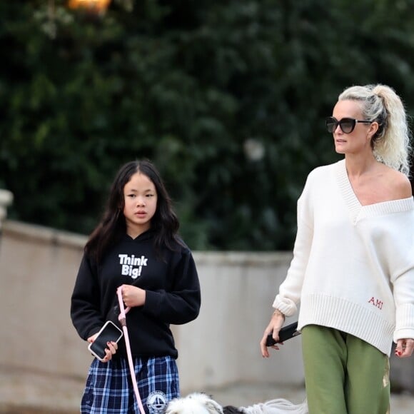 Laeticia Hallyday et ses filles Jade, 15 ans, et Joy, 11 ans, promènent leur chien Cheyenne dans le quartier de Brentwood à Los Angeles, pendant la période de confinement liée à l'épidémie de coronavirus (Covid-19), le 1er avril 2020.