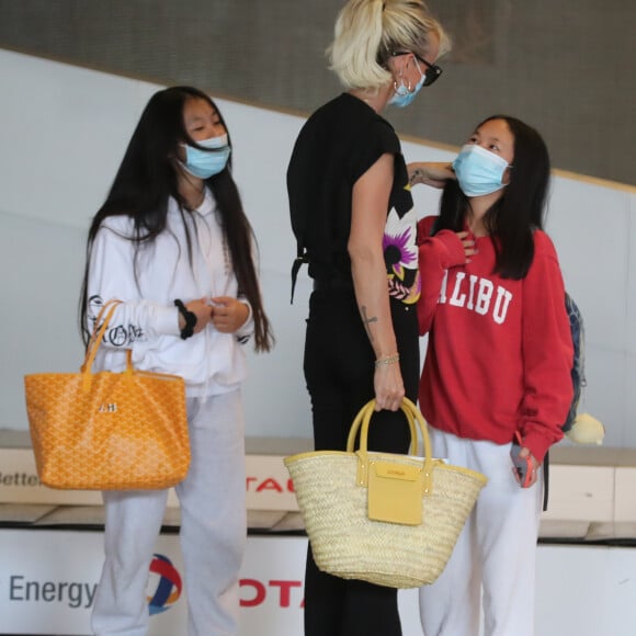 Laeticia Hallyday et ses filles Jade et Joy arrivent, avec des masques de protection contre l'épidémie de coronavirus (Covid-19), à l'aéroport de Paris-Charles-de-Gaulle à Roissy-en-France, France, le 18 juin 2020.