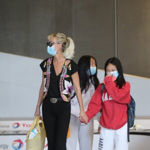 Laeticia Hallyday et ses filles Jade et Joy arrivent, avec des masques de protection contre l'épidémie de coronavirus (Covid-19), à l'aéroport de Paris-Charles-de-Gaulle à Roissy-en-France, France, le 18 juin 2020.