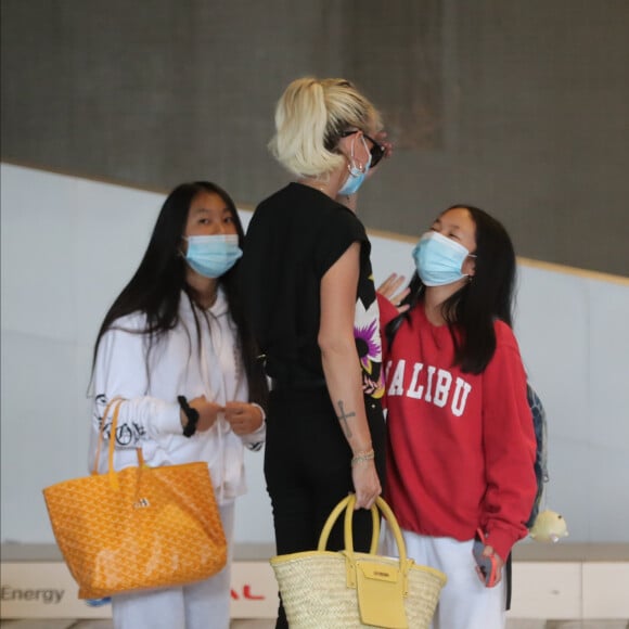 Laeticia Hallyday et ses filles Jade et Joy arrivent, avec des masques de protection contre l'épidémie de coronavirus (Covid-19), à l'aéroport de Paris-Charles-de-Gaulle à Roissy-en-France, France, le 18 juin 2020.