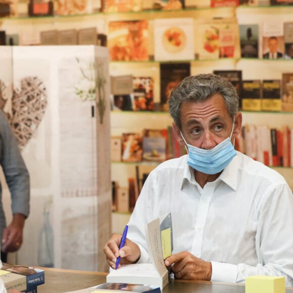 L'ancien président Nicolas Sarkozy dédicace son nouveau livre "Le temps des tempêtes" à l'espace culturel du centre commercial Leclerc Baleone à Ajaccio, en Corse le 24 juillet 2020. L'ancien président a profité de son séjour sur l'île de beauté pour commencer sa tournée des dédicaces. Les derniers livres de Nicolas Sarkozy ont été des succès, l'affluence du jour à Ajaccio semble confirmer cette règle. Le 24 juillet 2020 a Ajaccio, CORSE, FRANCE. Nicolas Sarkozy porte un masque lors de l'épidémie de Coronavirus (COVID-19). © Crystal Pictures /Bestimage