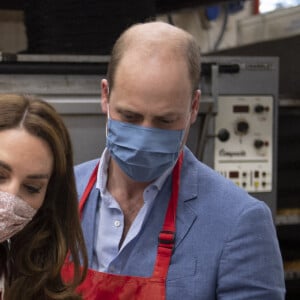 Le prince William, duc de Cambridge, et Kate Middleton, duchesse de Cambridge, font des bagels lors de leur visite à la boulangerie "Beigel Bake Brick Lane" à Londres, le 15 septembre 2020, pendant l'épidémie de coronavirus (Covid-19).