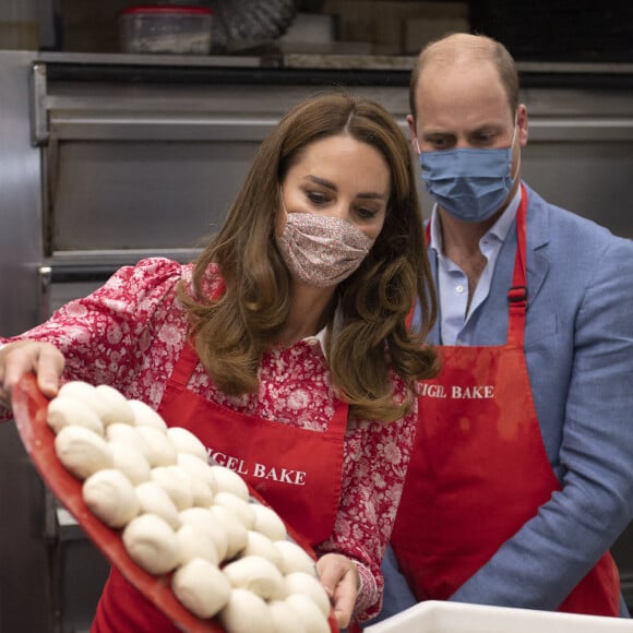 Le prince William, duc de Cambridge, et Kate Middleton, duchesse de Cambridge, font des bagels lors de leur visite à la boulangerie "Beigel Bake Brick Lane" à Londres, le 15 septembre 2020, pendant l'épidémie de coronavirus (Covid-19).