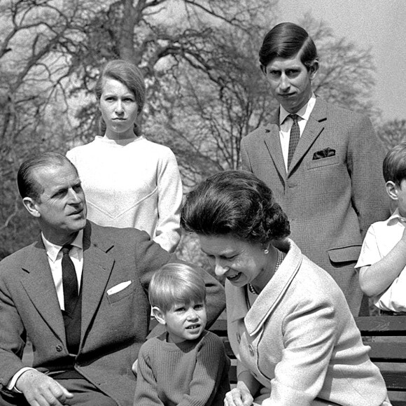 La reine Elizabeth II et l'un de ses corgis lors d'une séance photo en famille à Frogmore House en 1968, avec le duc d'Edimbourg, la princesse Anne, le prince Charles, le prince Edward (sur le banc) et le prince Andrew.