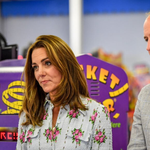 Le prince William, duc de Cambridge, et Kate Middleton, duchesse de Cambridge, lors de leur visite à "Island Leisure Amusement Arcade" à Barry (Royaume-Uni), le 4 août 2020. Venus pour discuter avec les commerçants des conséquences de l'épidémie de coronavirus (Covid-19) dans le secteur du tourisme, le couple princier n'a pas résisté au plaisir d'essayer quelques jeux de fête foraine.