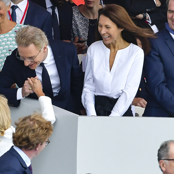 La Première dame Brigitte Macron salue Olivier Royant (directeur de Paris Match) et sa femme Delphine lors du 139ème défilé militaire du 14 juillet sur les Champs-Elysées, jour de la Fête Nationale. Paris, le 14 juillet 2019. © Lemouton-Gorassini-Perusseau/Bestimage