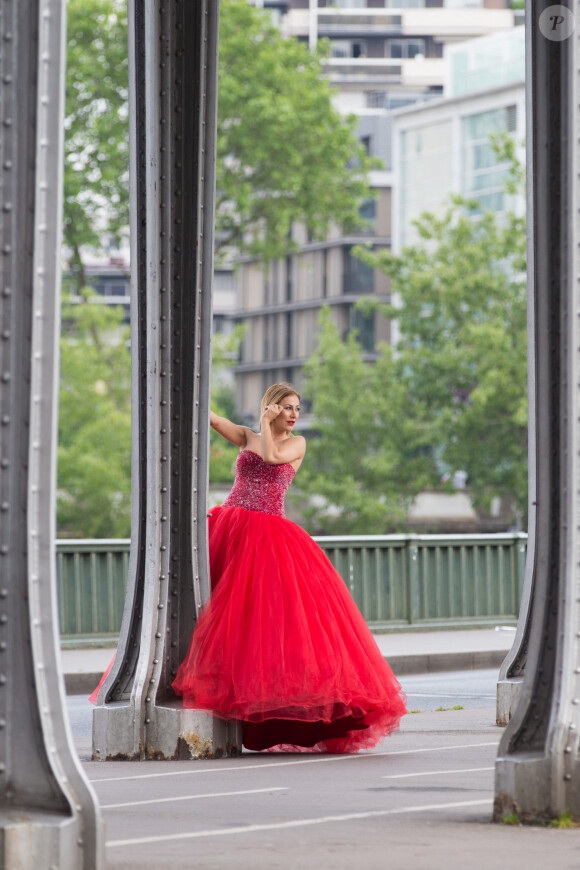 Gaëlle Petit (émission "Les Ch'tis" sur W9) pose dans une robe rouge lors d'un shooting photo sur le pont de Bir-Hakeim à Paris, le 26 mai 2016.