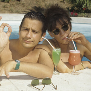 Archives En France, à Saint-Tropez, Laurent Gerra et Virginie Lemoine en vacances au Mas de Chastelas, dans la piscine le 10 août 1995.