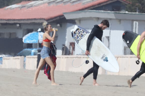 Exclusif - Prix spécial - No web - No blog - Miley Cyrus et son fiancé Liam Hemsworth font du surf et profitent du soleil entre amis sur une plage à Malibu, le 13 octobre 2017 