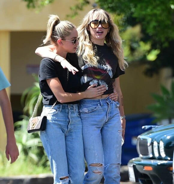 Miley Cyrus, qui porte un tee-shirt Metallica, et sa compagne Kaitlyn Carter se promènent, enlacées, dans les rues de Los Angeles. Le 14 septembre 2019.