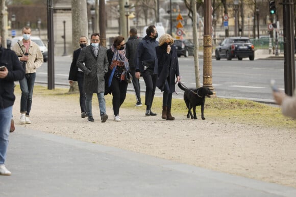 La première dame Brigitte Macron balade son chien, Némo, sur l'avenue des Champs-Élysées, à Paris, France, le 26 mars 2021. La première dame est accompagnée de Bernard Montiel et une amie ainsi que de ses gardes du corps. Elle s'est rendue à l'exposition des 20 statues du "Chat" de Philippe Geluck. © Christophe Clovis/Bestimage