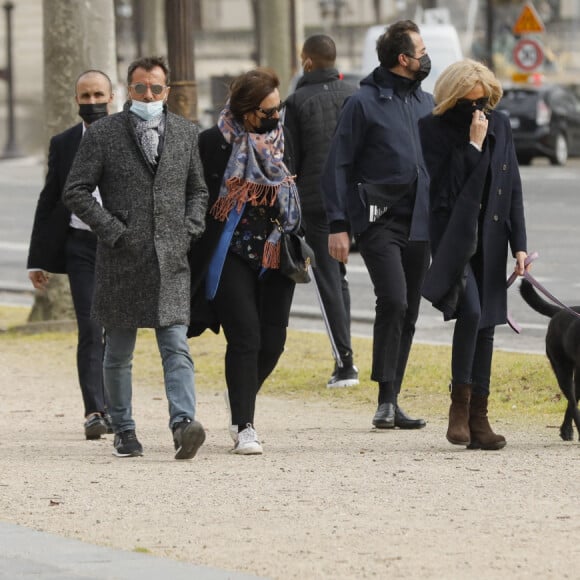 La première dame Brigitte Macron balade son chien, Némo, sur l'avenue des Champs-Élysées, à Paris, France, le 26 mars 2021. La première dame est accompagnée de Bernard Montiel et une amie ainsi que de ses gardes du corps. Elle s'est rendue à l'exposition des 20 statues du "Chat" de Philippe Geluck. © Christophe Clovis/Bestimage