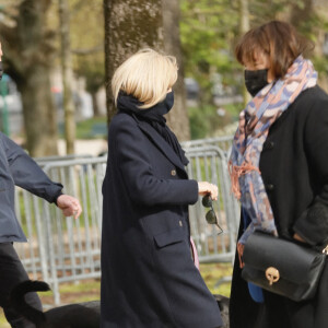 La première dame Brigitte Macron balade son chien, Némo, sur l'avenue des Champs-Élysées, à Paris, France, le 26 mars 2021. La première dame est accompagnée de Bernard Montiel et une amie ainsi que de ses gardes du corps. Elle s'est rendue à l'exposition des 20 statues du "Chat" de Philippe Geluck. © Christophe Clovis/Bestimage