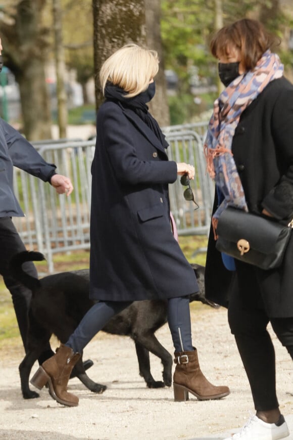 La première dame Brigitte Macron balade son chien, Némo, sur l'avenue des Champs-Élysées, à Paris, France, le 26 mars 2021. La première dame est accompagnée de Bernard Montiel et une amie ainsi que de ses gardes du corps. Elle s'est rendue à l'exposition des 20 statues du "Chat" de Philippe Geluck. © Christophe Clovis/Bestimage