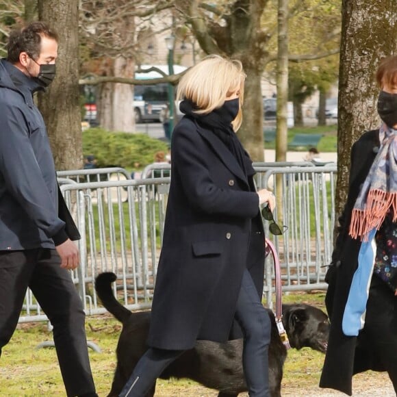 La première dame Brigitte Macron balade son chien, Némo, sur l'avenue des Champs-Élysées, à Paris, France, le 26 mars 2021. La première dame est accompagnée de ses amis Bernard Montiel et Fabienne Moszer et de ses gardes du corps. Elle s'est rendue à l'exposition des 20 statues du "Chat" de Philippe Geluck. © Christophe Clovis/Bestimage