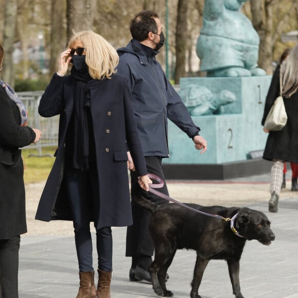 La première dame Brigitte Macron balade son chien, Némo, sur l'avenue des Champs-Élysées, à Paris, France, le 26 mars 2021. La première dame est accompagnée de Bernard Montiel et une amie ainsi que de ses gardes du corps. Elle s'est rendue à l'exposition des 20 statues du "Chat" de Philippe Geluck. © Christophe Clovis/Bestimage