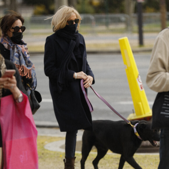 La première dame Brigitte Macron balade son chien, Némo, sur l'avenue des Champs-Élysées, à Paris, France, le 26 mars 2021. La première dame est accompagnée de Bernard Montiel et une amie ainsi que de ses gardes du corps. Elle s'est rendue à l'exposition des 20 statues du "Chat" de Philippe Geluck. © Christophe Clovis/Bestimage