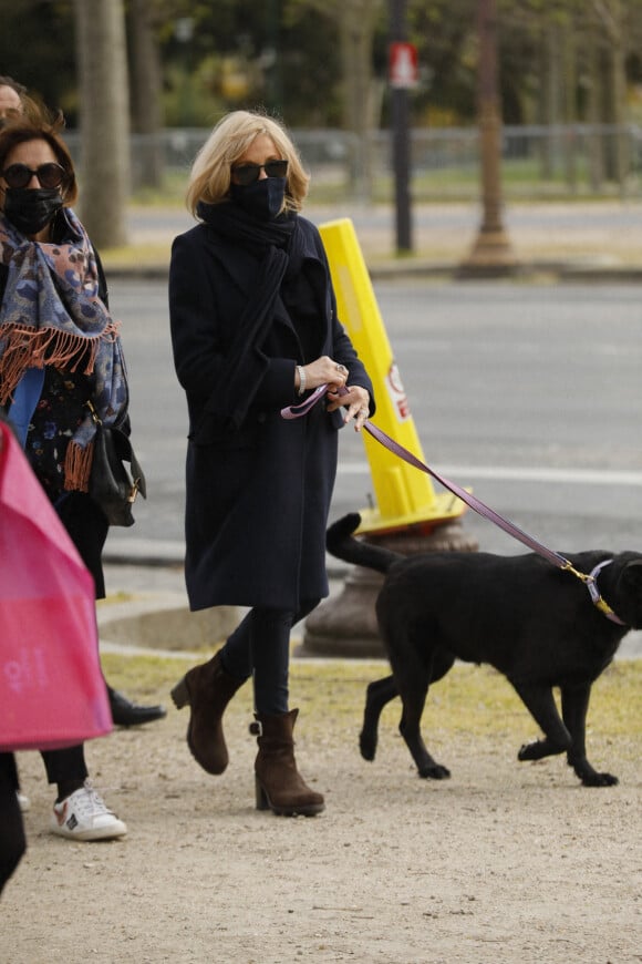 La première dame Brigitte Macron balade son chien, Némo, sur l'avenue des Champs-Élysées, à Paris, France, le 26 mars 2021. La première dame est accompagnée de Bernard Montiel et une amie ainsi que de ses gardes du corps. Christophe Clovis/Bestimage