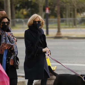 La première dame Brigitte Macron balade son chien, Némo, sur l'avenue des Champs-Élysées, à Paris, France, le 26 mars 2021. La première dame est accompagnée de Bernard Montiel et une amie ainsi que de ses gardes du corps. Elle s'est rendue à l'exposition des 20 statues du "Chat" de Philippe Geluck. © Christophe Clovis/Bestimage