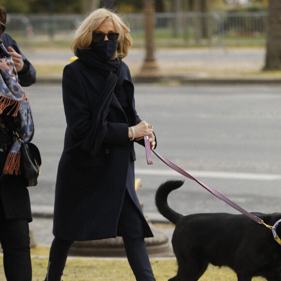 La première dame Brigitte Macron balade son chien, Némo, sur l'avenue des Champs-Élysées, à Paris, France, le 26 mars 2021. La première dame est accompagnée de Bernard Montiel et une amie ainsi que de ses gardes du corps. Elle s'est rendue à l'exposition des 20 statues du "Chat" de Philippe Geluck. © Christophe Clovis/Bestimage