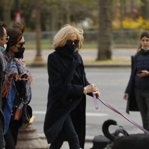 La première dame Brigitte Macron balade son chien, Némo, sur l'avenue des Champs-Élysées, à Paris, France, le 26 mars 2021. La première dame est accompagnée de Bernard Montiel et une amie ainsi que de ses gardes du corps. Elle s'est rendue à l'exposition des 20 statues du "Chat" de Philippe Geluck. © Christophe Clovis/Bestimage