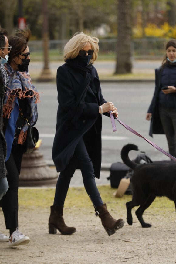 La première dame Brigitte Macron balade son chien, Némo, sur l'avenue des Champs-Élysées, à Paris, France, le 26 mars 2021. La première dame est accompagnée de Bernard Montiel et une amie ainsi que de ses gardes du corps. Elle s'est rendue à l'exposition des 20 statues du "Chat" de Philippe Geluck. © Christophe Clovis/Bestimage