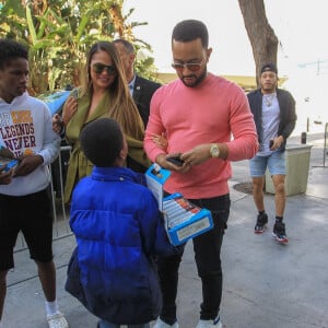 Chrissy Teigen et son mari John Legend achètent des friandises à un enfant dans les rues de Los Angeles, le 8 mars 2020 