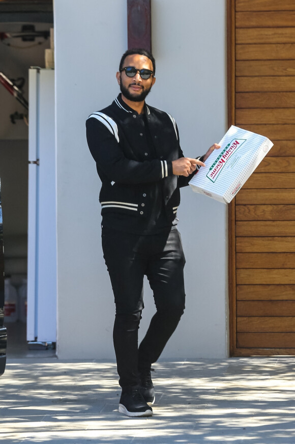 Exclusif - John Legend laisse une boîte de beignets Krispy Kreme pour les paparazzis alors que lui et sa femme Chrissy Teigen quittent leur maison de Malibu avec leur équipe de sécurité pendant le confinement lié à l'épidémie de Coronavirus (Covid-19) à Malibu, Los Angeles, le 16 avril 2020.Chrissy Teigen a fait un blague sur twitter à ce sujet.
