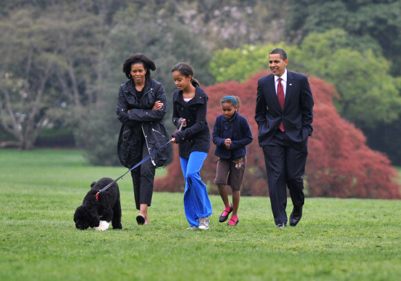 Barack Obama, son épouse Michelle Obama et leurs filles Sasha et Malia play avec leur chien Bo, à la Maison Blanche, en 2009.