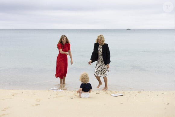 Carrie Johnson s'entretient avec la Première Dame des États-Unis, Jill Biden, lors du sommet des dirigeants du G7 à Carbis Bay, alors que Wilfred Johnson est assis sur la plage. 10 juin 2021