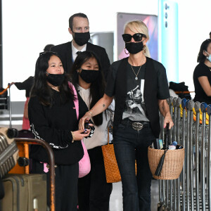 Laeticia Hallyday et ses filles Jade et Joy arrivent à l'aéroport de Roissy-Charles-de-Gaulle à Paris, le 27 juin 2021.