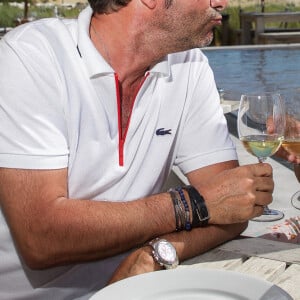 Bernard Montiel, présentateur et animateur radio pose sur la terrasse du restaurant "La Corniche" en dégustant un verre de vin blanc du château Smith Au Lafitte et quelques huïtres accompagné de la patronne du restaurant, Sophie Techoueyres. © Thibaud Moritz / Bestimage