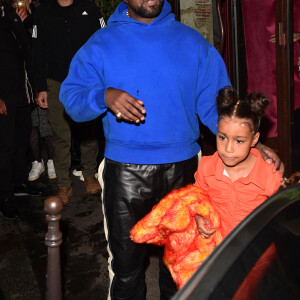 Kanye West, Kim Kardashian et sa soeur Kourtney emmènent leurs filles North West et Penelope Disick, faire un tour de carrousel au pied de la tour Eiffel après un dîner au restaurant "Ferdi".