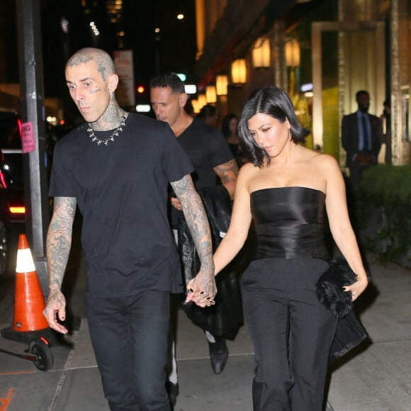 Travis Barker et sa compagne Kourtney Kardashian quittent le "Polo Bar" pour se rendre à la représentation de la pièce "Hadestown" à Broadway à New York, le 15 octobre 2021.