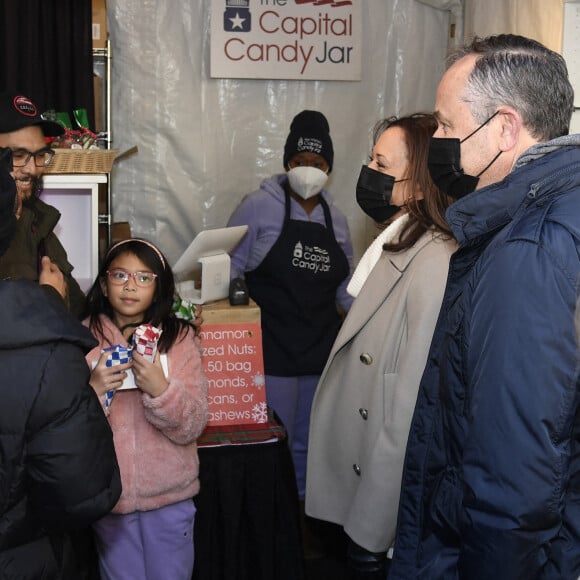 La vice-présidente des Etats-Unis, Kamala Harris, et son mari Douglas Ehmoff vont à la rencontre des commerçants sur le marché de Noël à Washington, le 28 novembre 2021.