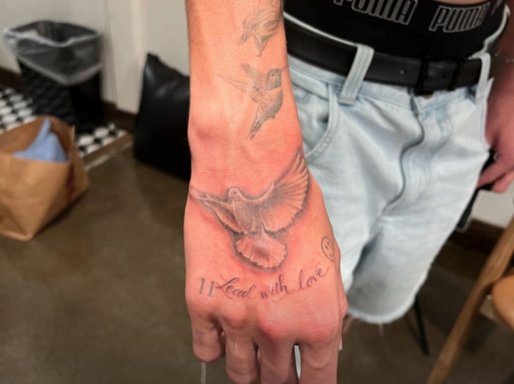 Romeo Beckham s'est fait tatouer un oiseau et la phrase "Lead With Love" sur la main droite.