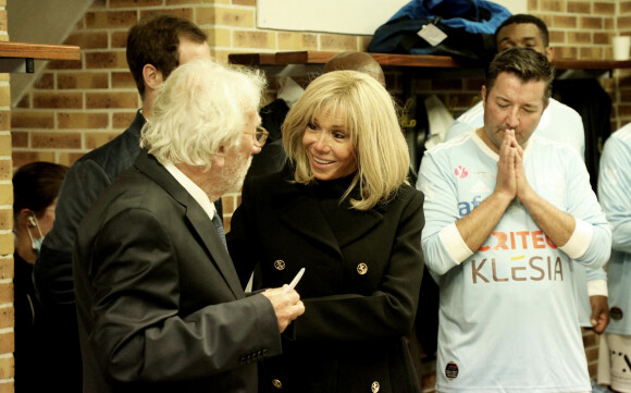 Jacques Vendroux, le manager général du Variété Club de France, La Première Dame Brigitte Macron, Karl Olive, le maire de Poissy dans les vestiaires avant de participer au match de football caritatif, au profit de la Fondation Hôpitaux de Paris-Hôpitaux de France dans la cadre de l'opération "Pièces jaunes", présidée par la Première Dame, opposant le Variétés Club de France à une sélection de soignants du centre hospitalier intercommunal de Poissy Saint-Germain-en-Laye, au stade Léo-Lagrange à Poissy, Yvelines, France, le 14 octobre 2021