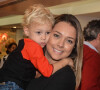 Le fils de Neymar, Davi Lucca, 2 ans pose dans les bras de sa mère Carolina Dantas, alors qu'il a défilé pour la marque Mini US au centre commercial Iguatemi à Sao Paulo, le 26 mars 2014.