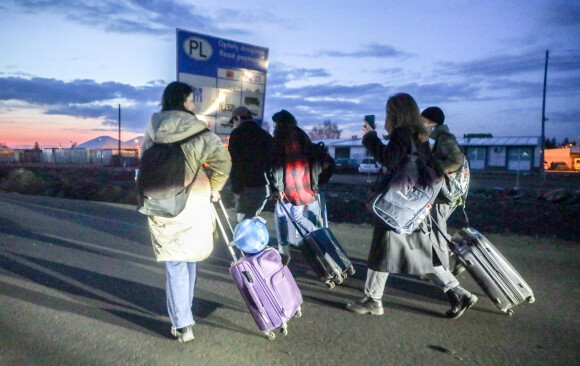 Des Ukrainiens fuyant leur pays après l'invasion russe ordonnée par Vladimir Poutine et arrivent au poste frontière polono-ukrainien à Medyka, dans le sud-est de la Pologne le 25 février 2022.