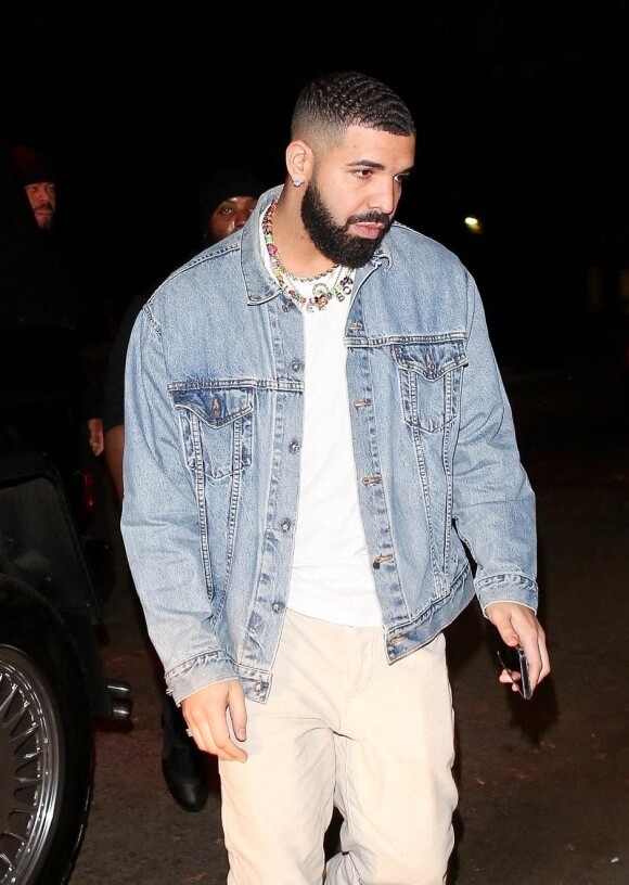Drake et une mystérieuse jeune femme semblent se rejoindre à la même soirée à Los Angeles, le 10 juin 2021.  Drake keeps a low profile as he appears to be arriving at an event solo but shortly after a mystery woman is seen entering the same event. Although Drake was surrounded by his entourage and the mystery women snuck in alone the two were said to have been linked at the event in Hollywood. Los Angeles. June 10th, 2021. 