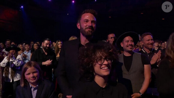 Jennifer Lopez reçoit un Icon Award sur la scène des "iHeartRadio Music Awards", sous le regard de son compagnon Ben Affleck avec son fils Samuel et de sa fille Emme. Los Angeles, le 22 mars 2022. 