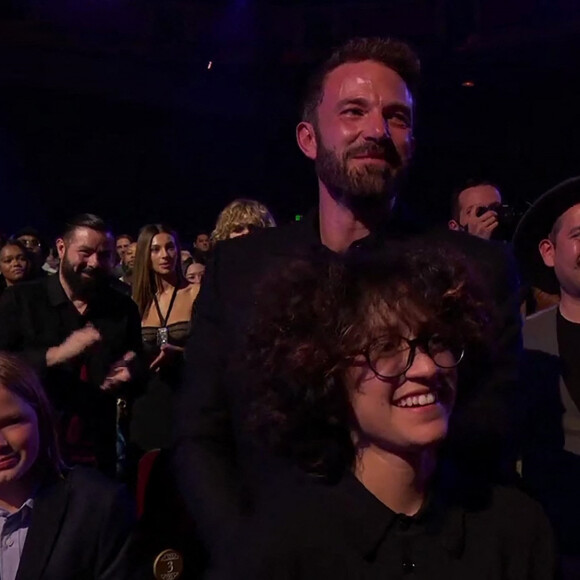 Jennifer Lopez reçoit un Icon Award sur la scène des "iHeartRadio Music Awards", sous le regard de son compagnon Ben Affleck et de sa fille Emme. Los Angeles, le 22 mars 2022. 