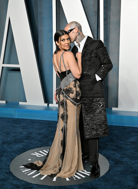 Kourtney Kardashian et son fiancé Travis Barker au photocall de la soirée "Vanity Fair" lors de la 94ème édition de la cérémonie des Oscars au Wallis Annenberg Center for the Performing Arts dans le quartier de Beverly Hills, à Los Angeles, Californie, Etats-Unis, le 27 mars 2022. 