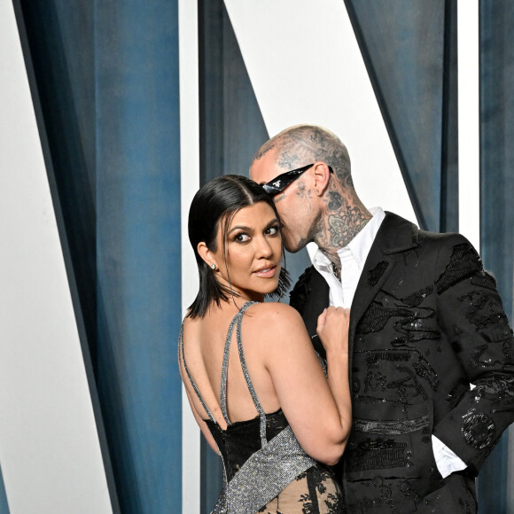 Kourtney Kardashian et son fiancé Travis Barker au photocall de la soirée "Vanity Fair" lors de la 94ème édition de la cérémonie des Oscars au Wallis Annenberg Center for the Performing Arts dans le quartier de Beverly Hills, à Los Angeles, Californie, Etats-Unis, le 27 mars 2022. 