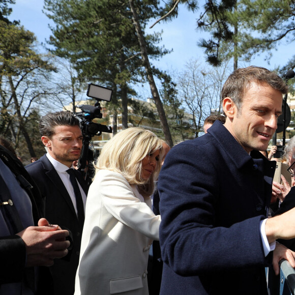 Le président de la République française, Emmanuel Macron accompagné de son épouse, Brigitte Macron, vote pour le premier tour de l'élection présidentielle au Touquet, France, le 10 avril 2022