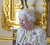 La reine Elisabeth II d'Angleterre parcourt l'exposition d'objets de la société d'artisanat britannique Halcyon Days, pour marquer son jubilé de platine, au château de Windsor, le 23 mars 2022.