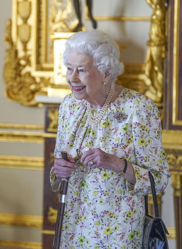 La reine Elisabeth II d'Angleterre parcourt l'exposition d'objets de la société d'artisanat britannique Halcyon Days, pour marquer son jubilé de platine, au château de Windsor, le 23 mars 2022.