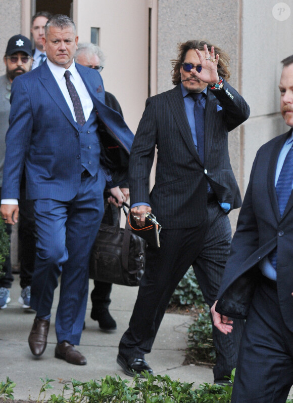 Johnny Depp et ses avocats sortent de leur hôtel à McLean, Virginie, Etats-Unis, le 13 avril 2022, pour se rendre au tribunal pour le quatrième jour du procès en diffamation avec son ex A.Heard, qui l'a accusé de violences conjugales. Johnny Depp salue ses fans avant de monter dans sa voiture. 