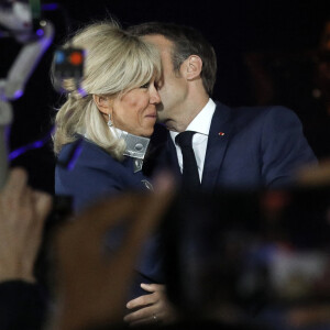 Le président français Emmanuel Macron et sa femme Brigitte Macron célèbrent la victoire du second tour de l'élection présidentielle française au Champ-de-Mars devant la Tour Eiffel, à Paris : doux baiser du gagnant pour son épouse